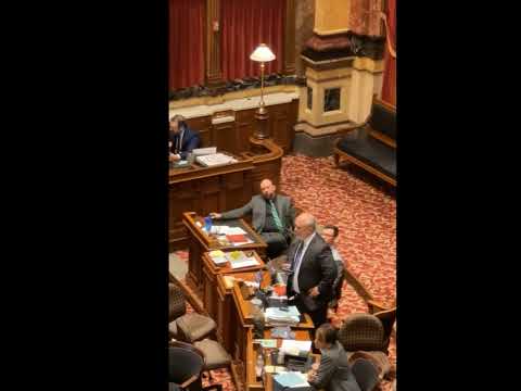 Clerk waves rainbow flag while Sen. Carlin discusses LGBTQ agenda being pushed in schools