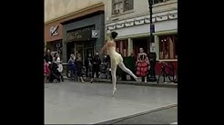 Two ballerinas dance on the street.