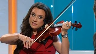 Spelmannen Kalle Moraeus försöker lära Camilla Läckberg spela fiol