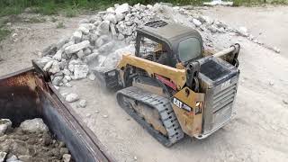 CAT 259D compact track loader skidsteer loading dump truck with big rocks
