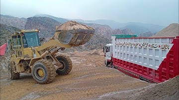 Caterpillar 950B wheel loader loading Big truck with raw material in a mining site