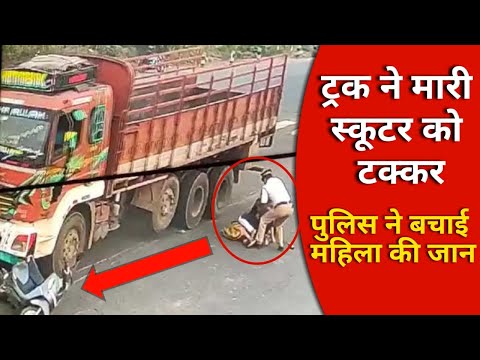 Truck hits a scooter, and women fall beside the wheel of the truck; The traffic policeman saved them