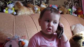 Малышка говорит по телефону с бабушкой..