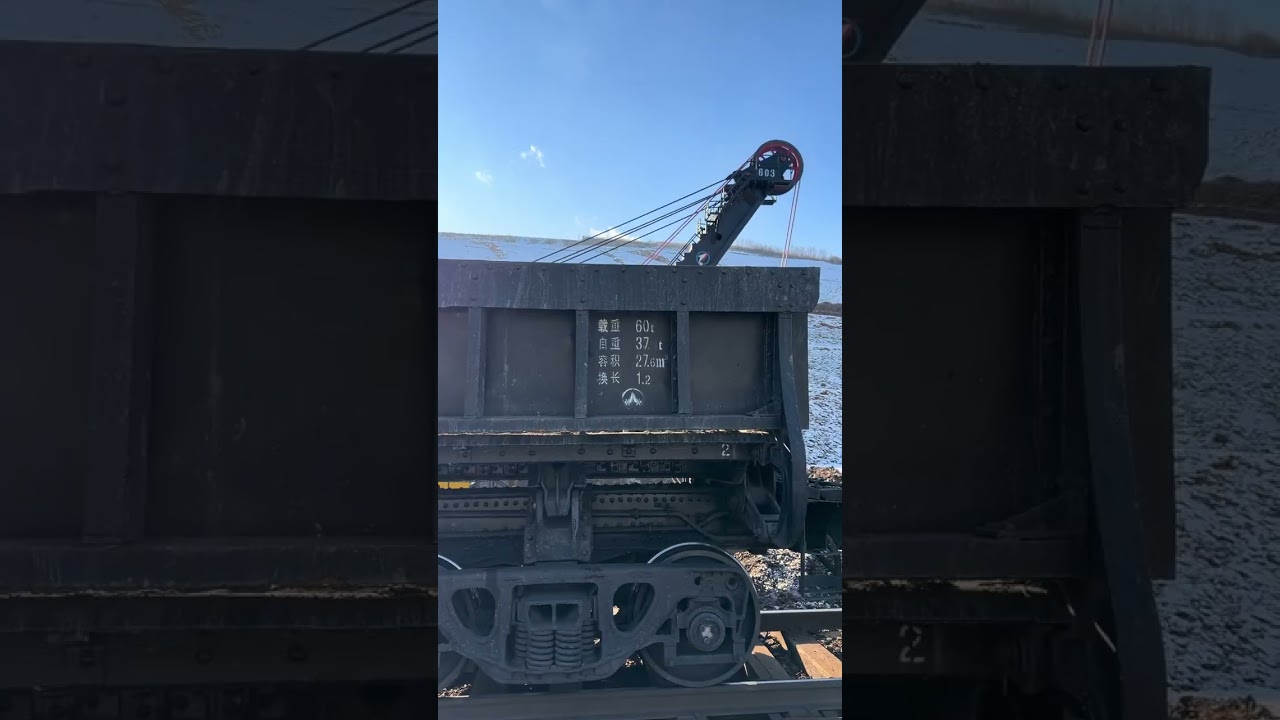 Large excavators are mining ore and loading it onto trains.