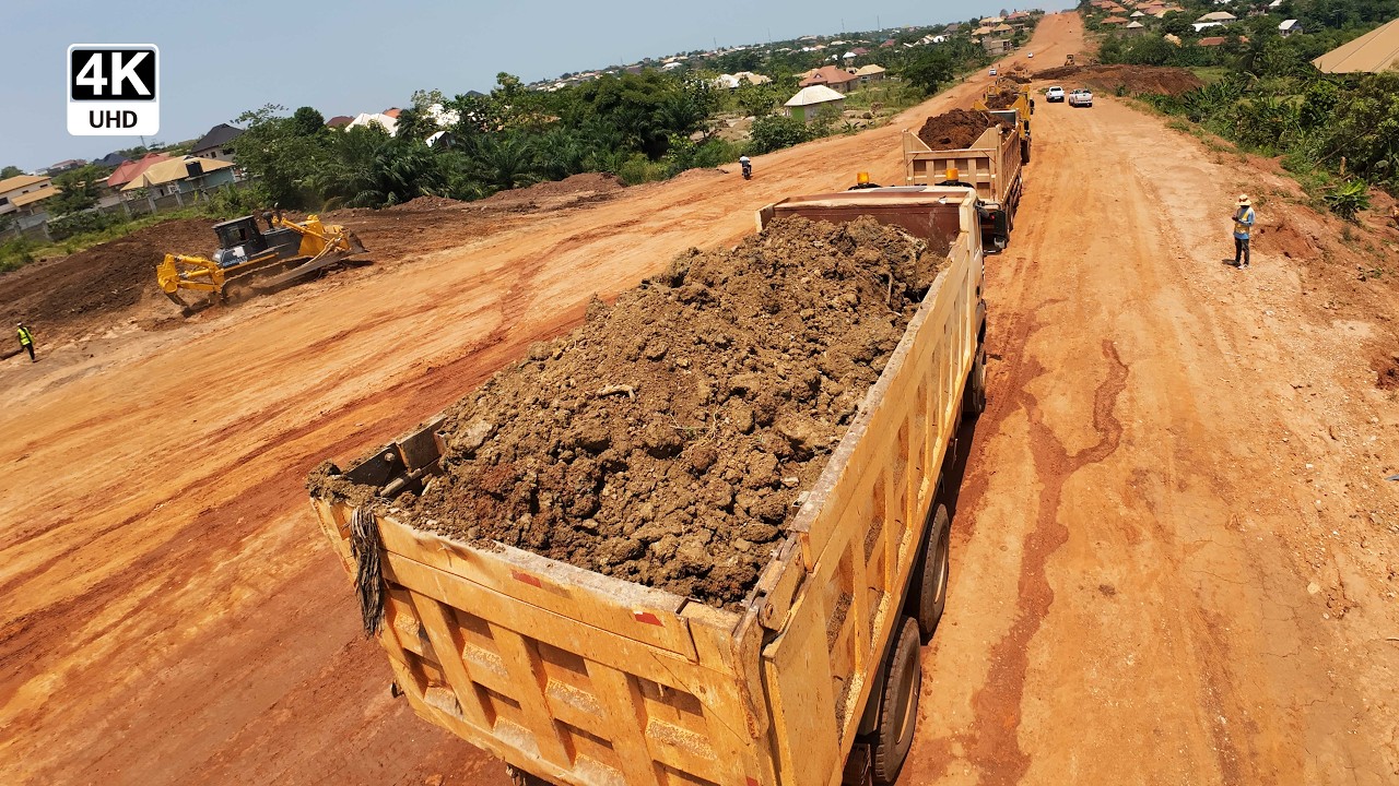 Dump Trucks Offloading Earth as Dozer Shapes Steep Section 4K - YouTube