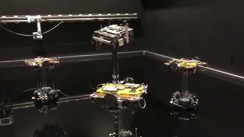 Four spacecraft simulators hovering over the flat floor