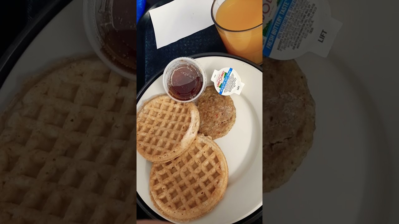 two cold soggy generic eggos cold sausage syrup butter orange juice.