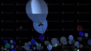 Colorful blinking helium balloons flying up to night sky