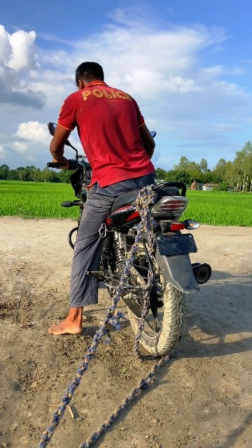 Who is tying the back of the motorcycle?