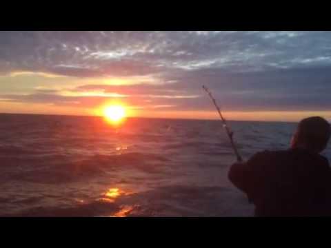 Legh catching a snapper at sunrise aboard Class Act Charters