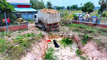 Great bulldozer skill pushing soil and filling land with dump truck