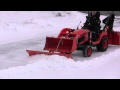 Snow blower, plow and bucket on Kubota BX clearing hard snow