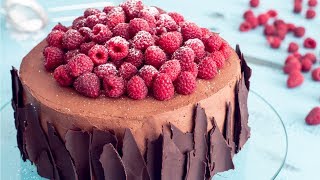 ... - moist chocolate cake filled with raspberries and ganache,
frosted whipped ganache decorated fresh raspberr...