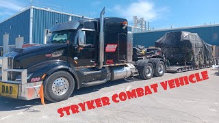 PETERBILT 579 HAULING STRYKER COMBAT VEHICLE ON RGN