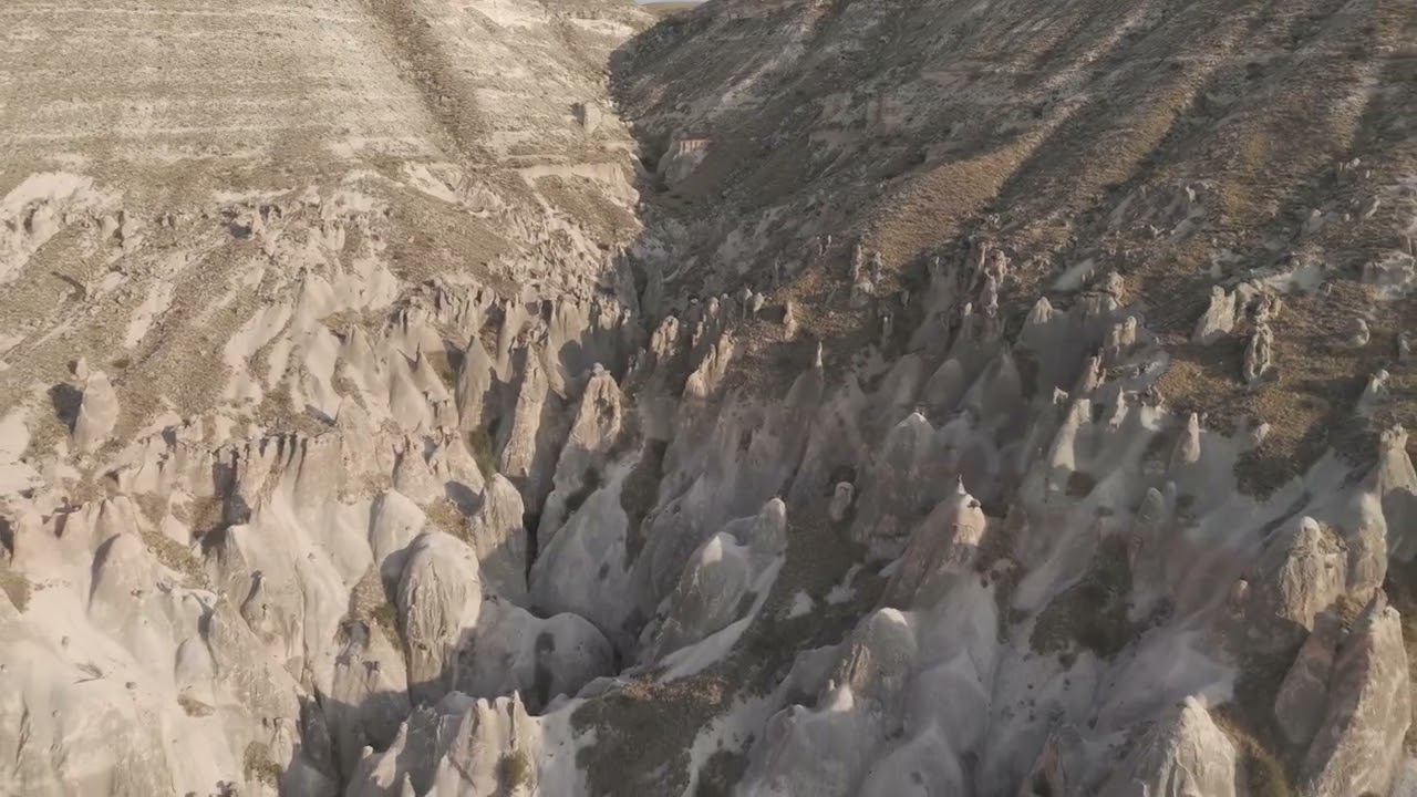 D-Log M. Goreme, Nevsehir, Turkey. Panoramic drone flight over Cappadocia valley at sunset, showi...