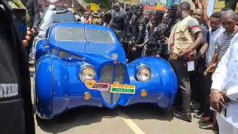 Cheddar (Nana Kwame Bediako) arrives in grand style with a Rolls Royce, among other luxury cars.