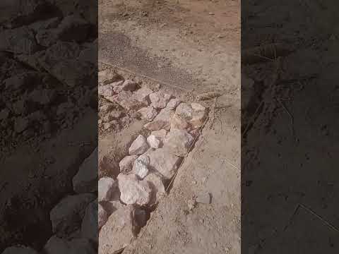 وضع الحجارة في أساس الحظيرة الطينية خطوة مهمة في البناء التقليدي القوي