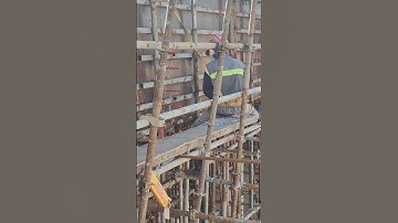 2 workers try to remove side formwork of girder beam