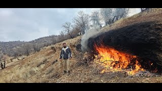 Fire carving  a mountain and building survival shelter in the heart of rock. in winter storm
