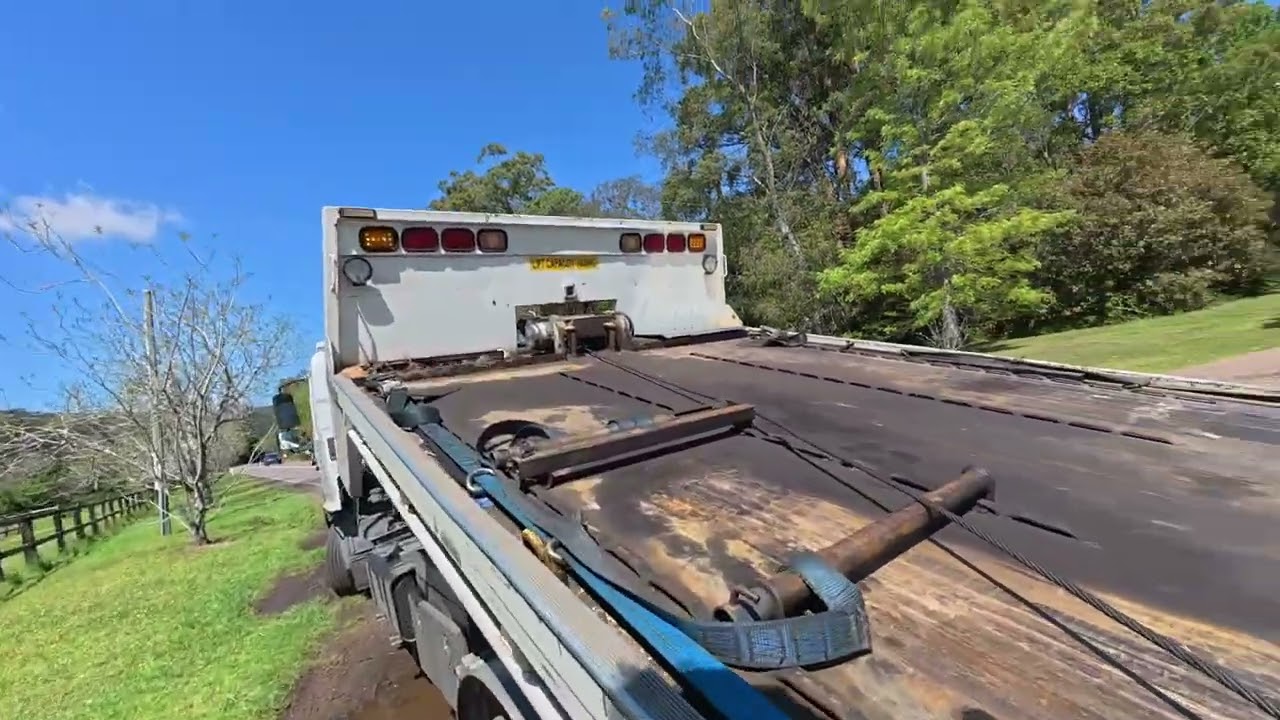 rough right angle pick up with a tilt tray / roll back . Towing for a wrecking yard
