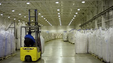 Bags handling to stacking in warehouse by forklift. Forklift with a big bag. Yellow forklift in