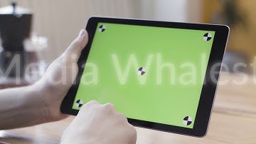 Close up of man hands holding digital tablet computer with green screen, scrolling, sliding and