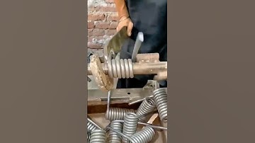 Metal wire being coiled into springs using a winding machine