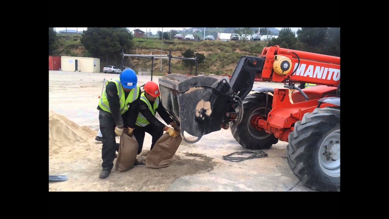 Telehandler filling sandbags using cement mixer attachment