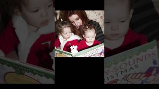 Lisa Marie Presley reading a Christmas-themed book to her twin daughters.