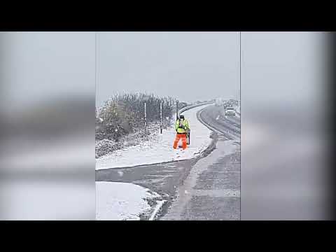 Bizarre video shows dedicated workie cutting grass at side of A9 - during heavy snowfall