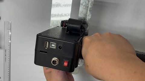 Handheld inkjet printer with solvent yellow ink cartridge printing MFG EXP on plastic container