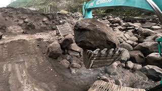 The excavator loads the rock so the sand can be mined