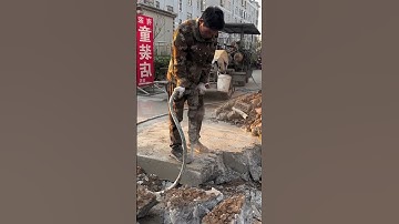 Using a vibratory chisel to break up concrete on a rural road