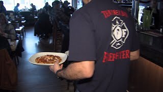 Firefighters serve guests at Boston Pizza for Toys for Tots