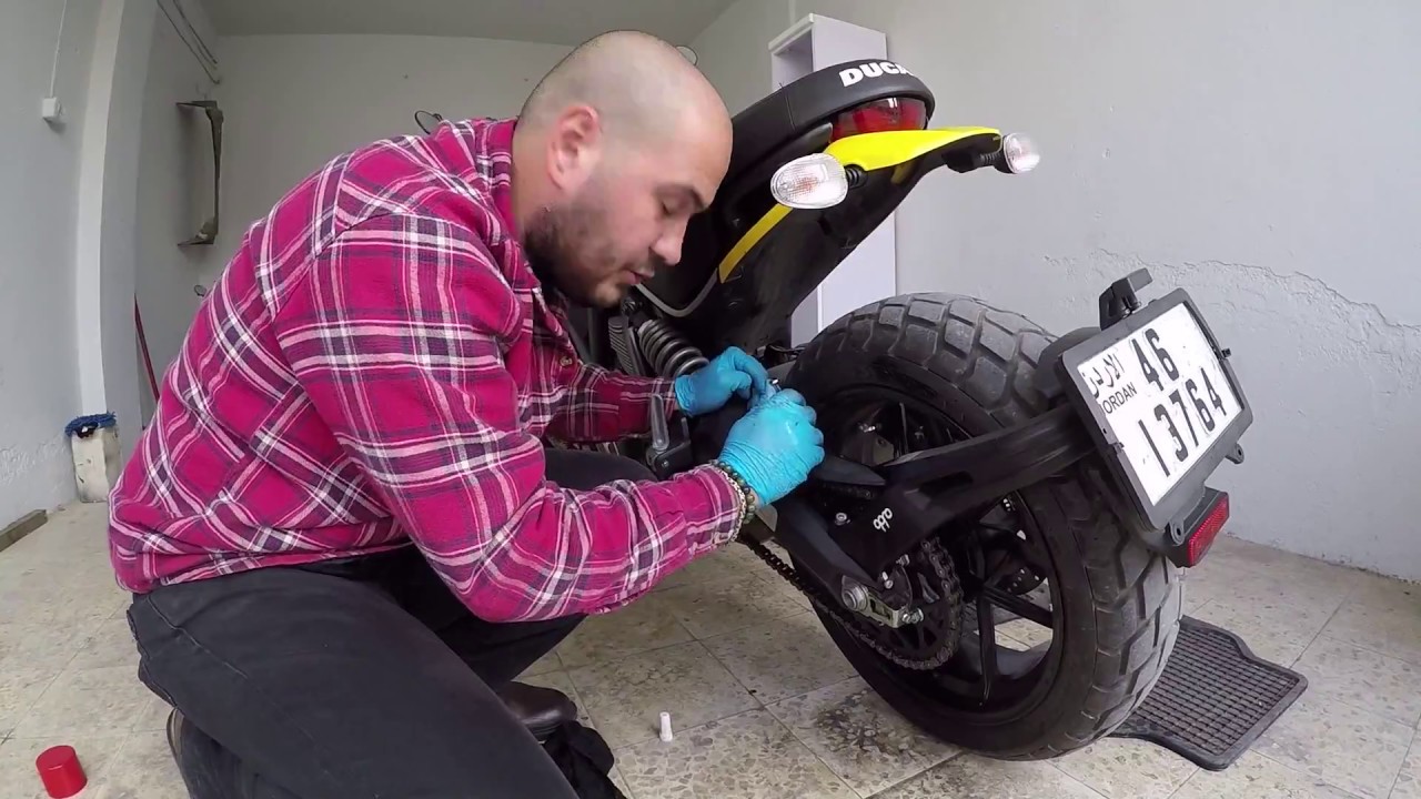 Cleaning and lubricating a motorcycle chain (Arabic).تنظيف