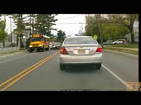 Car passes school bus with flashing lights