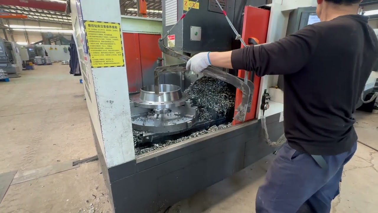 Fulihua CNC drilling operator removing finished flange from machine