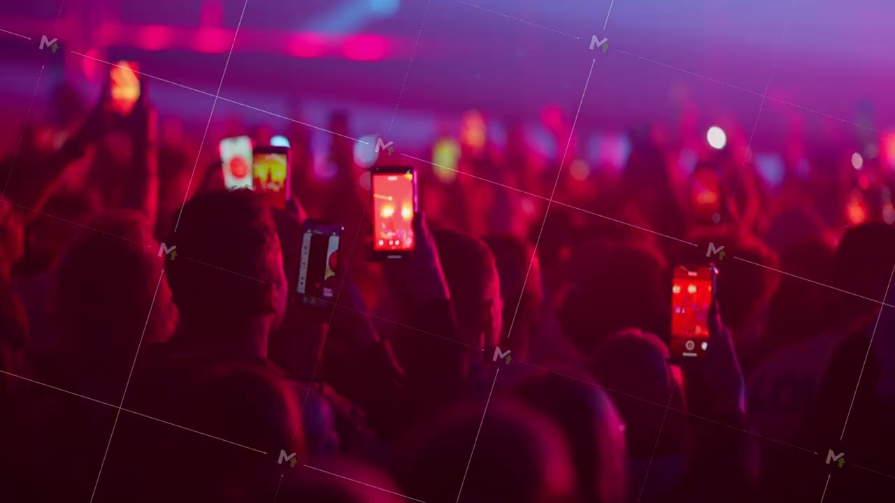 Slow motion audience dancing and filming concert