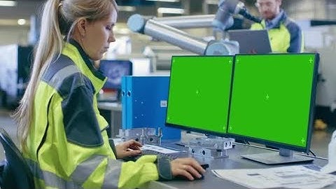 At the Factory: Female Mechanical Engineer Works on Personal Computer with Two Green Mock-up Screen