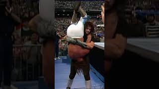 Undertaker drops Jake Roberts with a devastating Tombstone on the ringside floor