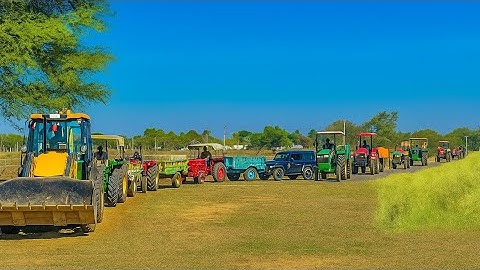 JCB 3DX Machine leading a Powerful Convoy of Tractors Moving Together Across The Open Field 