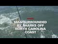 Man surrounded by sharks in a feeding frenzy off the coast of North Carolina