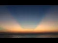 Calm water with sunset crepuscular rays at Sunabe