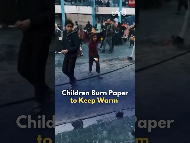 ⁣Gazan children burn paper to keep warm.