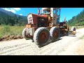 Vintage Grader fixing a Potholed Gravel Driveway