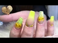 Super bright yellow acrylic nails with dried flowers