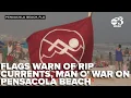 Red and purple flags warn of rip currents and man o war at Pensacola Beach