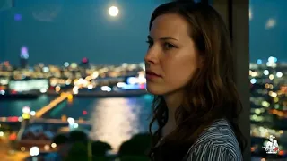 Она сидит напротив у окна 