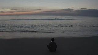 رجل على الشاطى يتأمل غروب بحر 4k فيديو للمونتاج بدون حقوق 