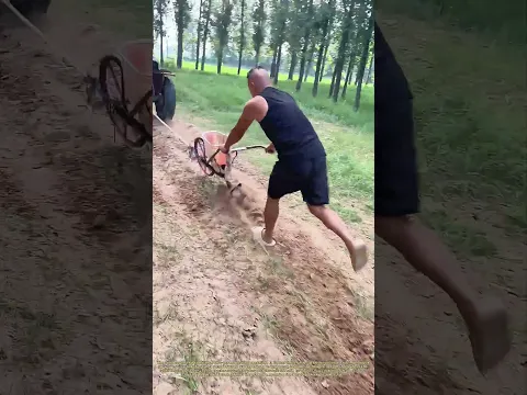 Tractor and Tiller: A Farmer Plows While Another Guides the Blade